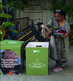 A resident dropping clothes into a Green Closet collection box