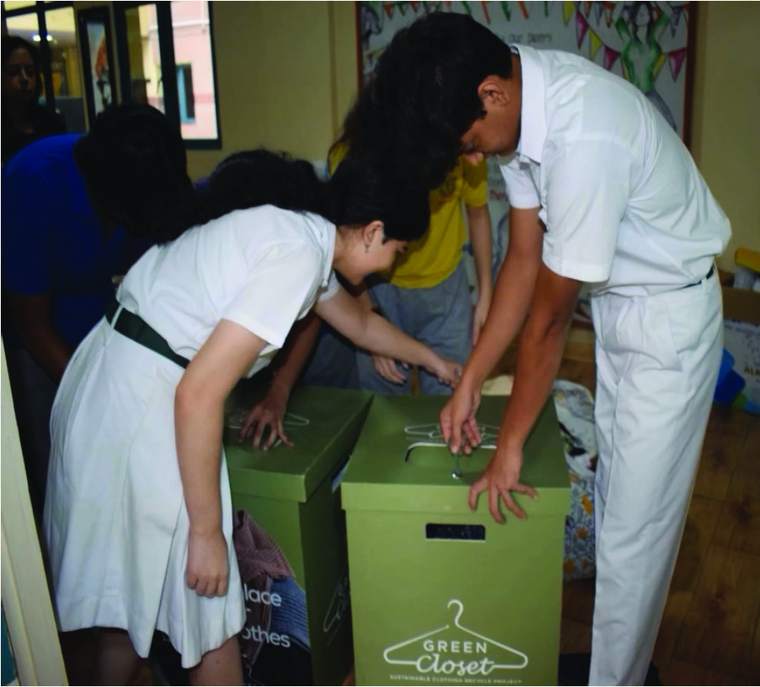 Students sealing a Green Closet donation box at school